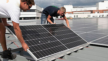 Zonnepanelen worden op een dak gelegd door installateurs