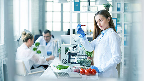 Mensen in witte jassen in een laboratorium met eten op het werkblad