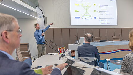 Spreker Erik van der Veer houdt een presentatie. Hij staat bij het scherm.