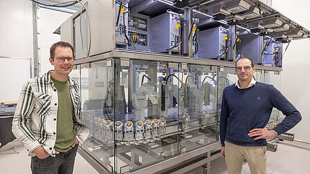 Hendrik Kemp en Niek van den Top staan voor de machine voor de geslachtsbepaling van de eieren.