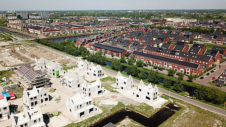 Op de foto een deel van een woonwijk in aanbouw en een ander deel van de woonwijk is klaar en bewoonbaar.