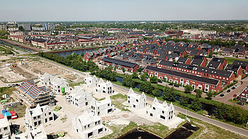 Luchtfoto met woningen in aanbouw en nieuwe woningen.