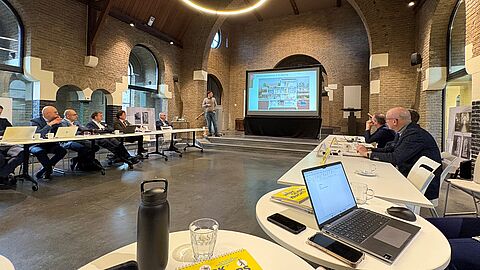De boardleden zitten om tafel in een vergaderzaal bij Koninklijke Ginkel Groep. De locatie is een oude kerk in Veenendaal.