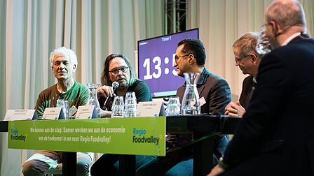 Tafelgasten van rondetafelgesprek 2 in gesprek met de gesprekleider.