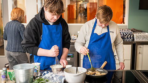 leerlingen zijn in de keuken aan het bakken. 