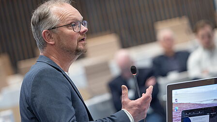 Programmamanager Rick de Jongh staat bij scherm. Hij is aan het presenteren.