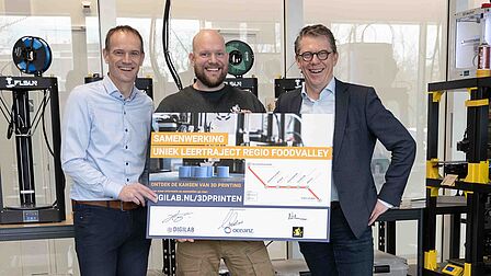Erik van der Garde, CEO Oceanz 3D Printing, Niels van Huenen, Instructeur Makerslab en Joop Hazeleger, programmamanager DigiLab Regio Foodvalley houden het ondertekende document vast. 
