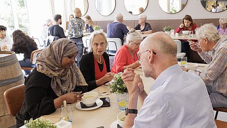 Buurtbewoners genieten zichtbaar van de lunch.