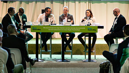 Tafelgasten van rondetafelgesprek 3 in gesprek met de gesprekleider.