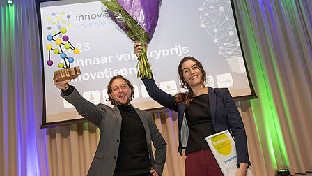 Saia Agrobotics uit Wageningen wint de Innovatie vakjuryprijs. Lianne Scholtens en Ruud Barth houden de prijs en bloemen vast. 