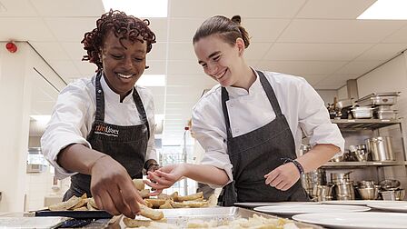 Twee studenten bereiden de verse frieten. 