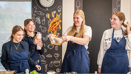 De zoete aardappelfriet worden in de lucht gegooid door één van de leerlingen. 