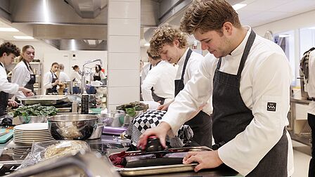 Studenten zijn aan de slag met gered voedsel. Een student is bieten aan het raspen. 