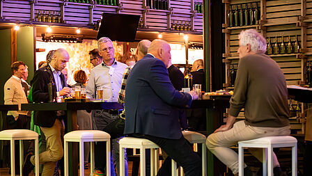 aanwezigen zijn aan het netwerken tijdens de borrel.