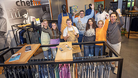 Groepsfoto van de werknemers in het altelier. Ze houden de prijs in de hand.