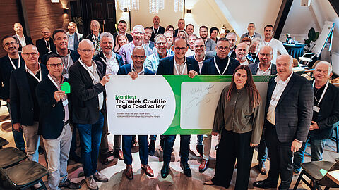 Groepsfoto met partners, zij houden het ondertekende  manifest Techniek coalitie Regio Foodvalley vast.