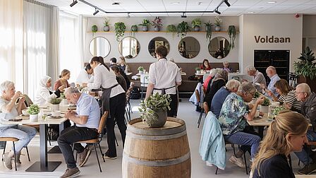 Overzichtsfoto van de mensen die aan het lunchen zijn in het restaurant van Vakschool Wageningen.