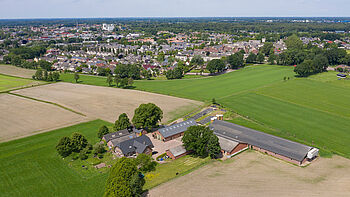 Luchtfoto van het buitengebied De Valk, vergezicht van landschap, boerderij en woningbouw 