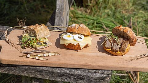 De drie broodjes vallei liggen gepresenteerd op een houten plank: Broodje lupine spread, broodje kaas en broodje bal  