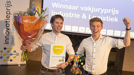 Stalero uit Barneveld won de vakjuryprijs in de categorie Industrie en Logistiek. De medewerkers staan juichend op het podium met bloemen en de prijs in de hand.