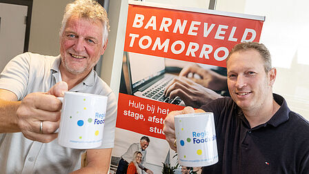 Joop van Veelen, managing connector van Barneveld Tomorrow en Gerrit Valkenburg, bestuurslid van ICT Campus en ICT Valley houdn beide een koffiemok in de hand.