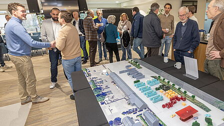 Ontvangst in de foyer. Er ligt een 3D maquette op de tafel. 