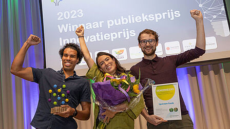 Upstream uit Wageningen wint de Innovatie publieksprijs. Het team houdt de prijs en bloemen vast.  