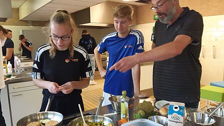 Twee studenten van Dullon college Ede krijgen instructies van kok Giel Dons.