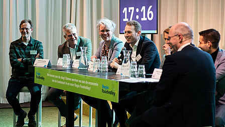 Tafelgasten van rondetafelgesprek 1 in gesprek met de gesprekleider.