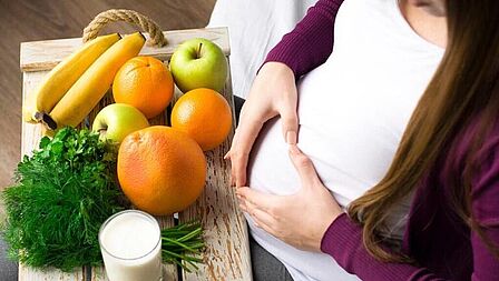 zwangere vrouw met fruit voor zich