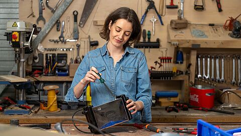een vrouw repareert een broodrooster