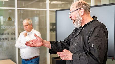 Chek-kok Giel Dons geeft uitleg over de masterclass en de gerechten die gemaakt gaan worden. Hij staat in de keuken