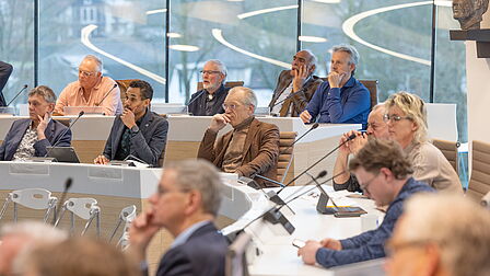Een overzichtsfoto van een aantal deelnemers in de zaal die aandachtig aan het luisteren zijn.