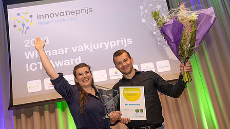 BFG Warehouding uit Nijkerk wint de ICT Award vakjuryprijs. Rosa van Sas-Andriesen en Stefan van Dijk houden de prijs en bloemen vast.  