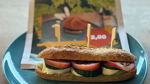de leerlingen hebben een nieuw broodje voor de kantine ontwikkeld. Op de foto staat een pistolet met tomaat, pesto en komkommer.